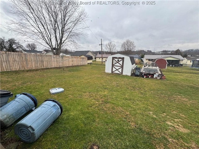 view of yard with an outdoor structure, a storage unit, and fence