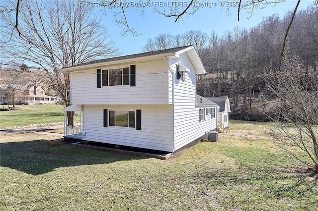 view of property exterior with a lawn and cooling unit