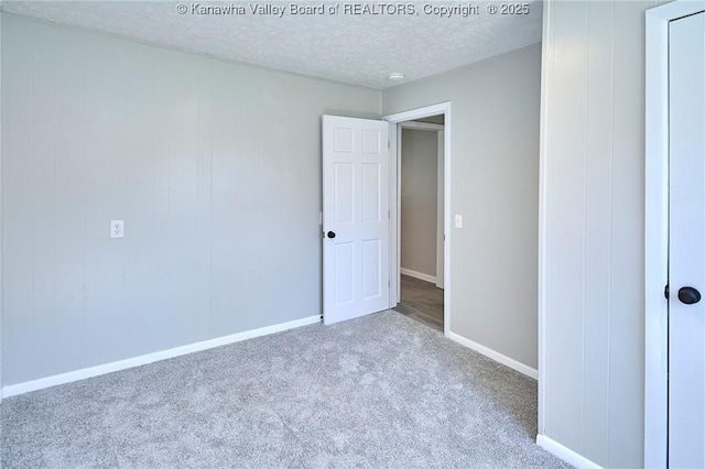 unfurnished bedroom featuring baseboards, a textured ceiling, and carpet flooring