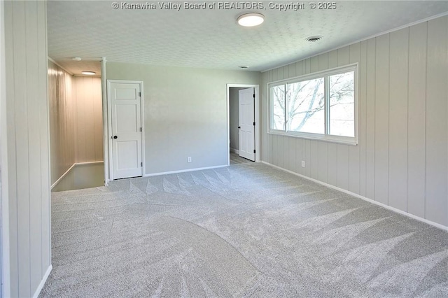 carpeted empty room with visible vents and baseboards