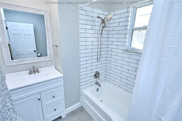 bathroom featuring baseboards, wood finished floors, vanity, and shower / bath combination with curtain