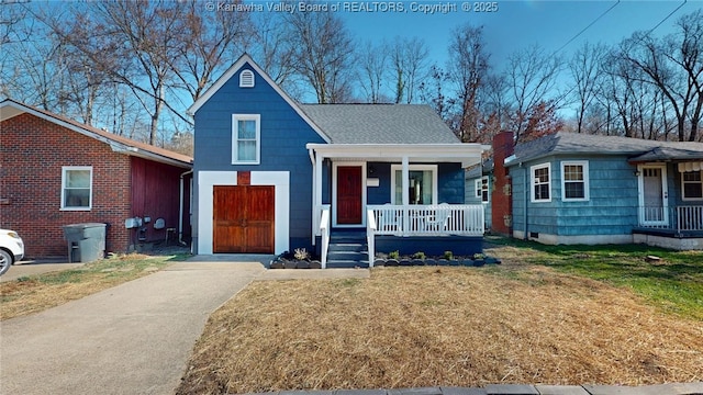 view of front facade with driveway, a porch, a front lawn, and a shingled roof