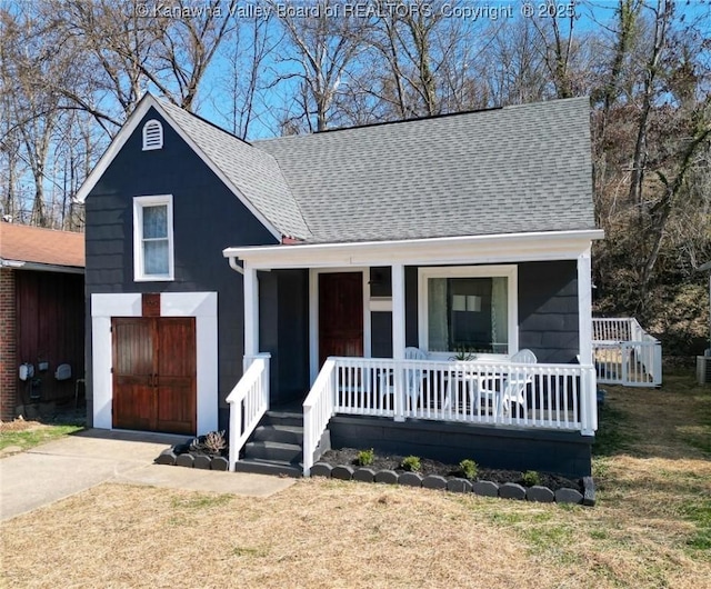 view of front of property with driveway, a front lawn, a porch, a shingled roof, and a garage