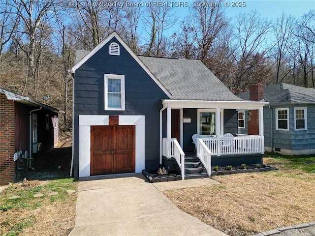 view of front facade with a porch, a front lawn, driveway, and roof with shingles