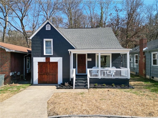 view of front facade with a front lawn, a porch, concrete driveway, and roof with shingles