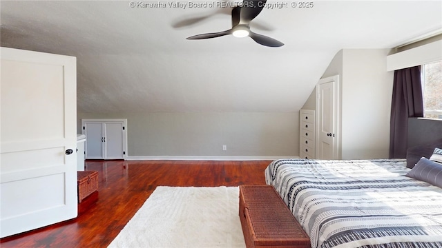 bedroom featuring baseboards, lofted ceiling, wood finished floors, and a ceiling fan