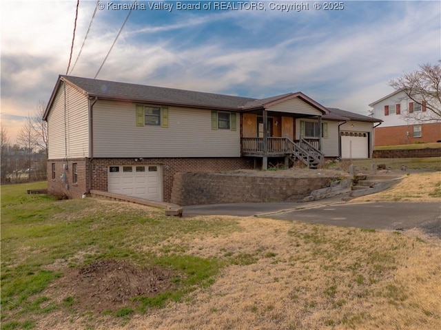 single story home featuring brick siding, covered porch, an attached garage, and a front yard