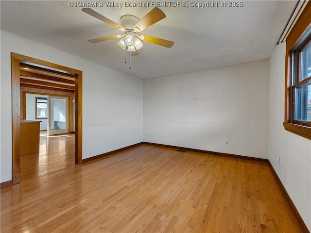 spare room featuring light wood-style floors, baseboards, and ceiling fan