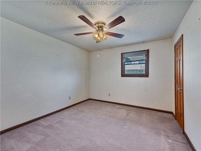 unfurnished room featuring visible vents, baseboards, ceiling fan, light carpet, and a textured ceiling