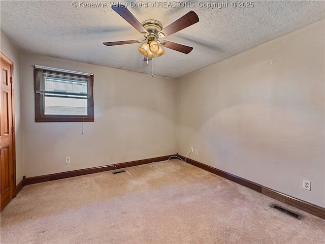 spare room with baseboards, visible vents, carpet floors, and a textured ceiling