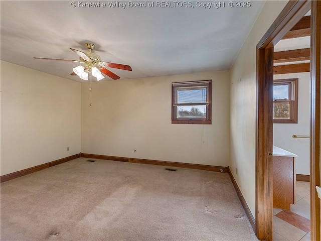 spare room with ceiling fan, baseboards, a wealth of natural light, and light carpet