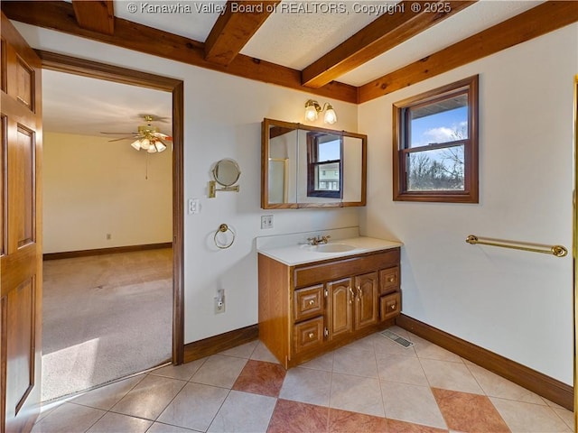 bathroom with beam ceiling, tile patterned floors, and baseboards