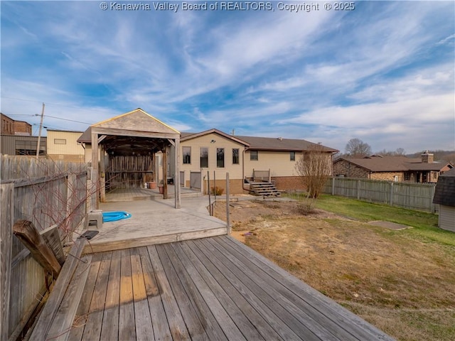 wooden deck with a gazebo, a lawn, and a fenced backyard