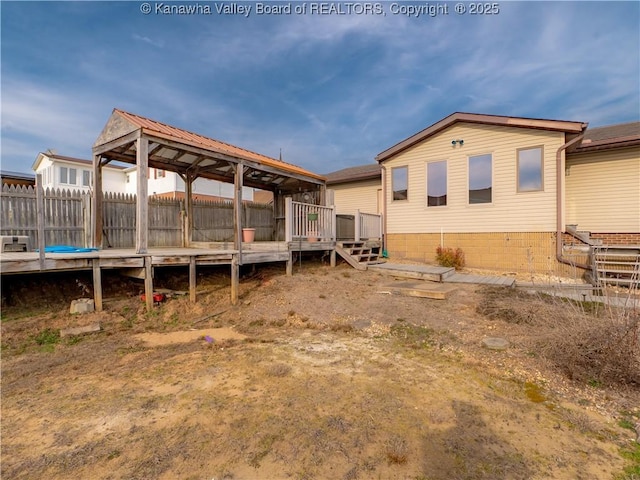 back of house with a deck and fence