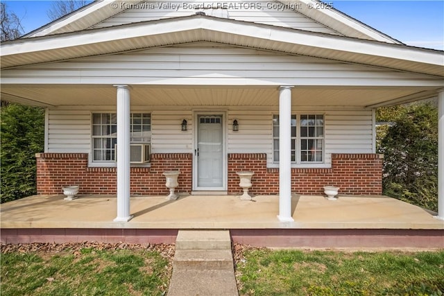 entrance to property featuring brick siding and a porch