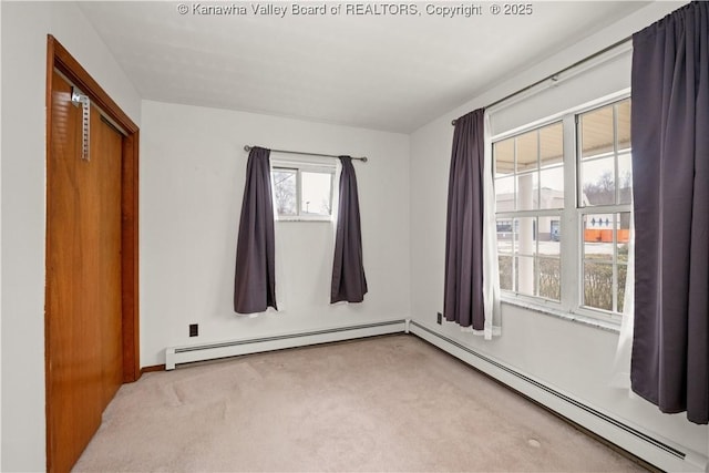 unfurnished bedroom with a baseboard heating unit and carpet flooring