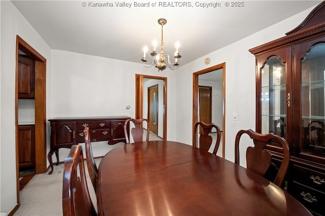 dining area with a notable chandelier and light carpet
