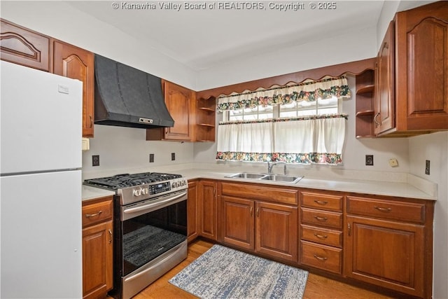 kitchen with custom range hood, open shelves, a sink, freestanding refrigerator, and gas stove