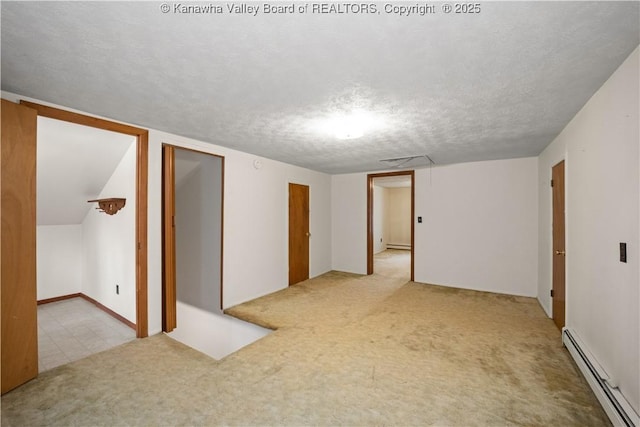 carpeted spare room with baseboard heating, a textured ceiling, a baseboard heating unit, and visible vents