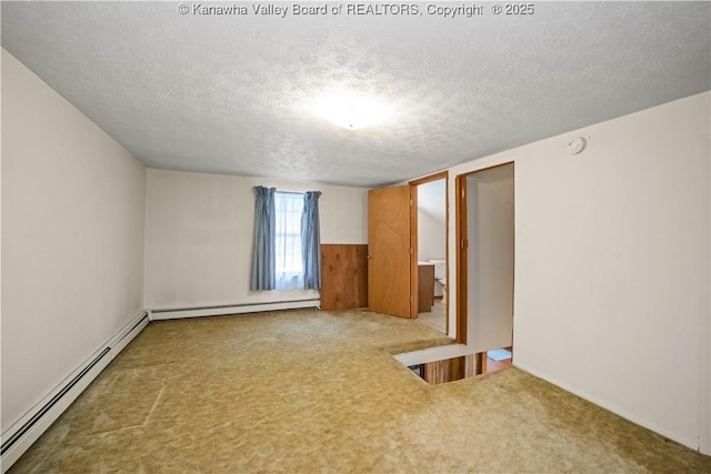 spare room with carpet flooring, a textured ceiling, and a baseboard radiator