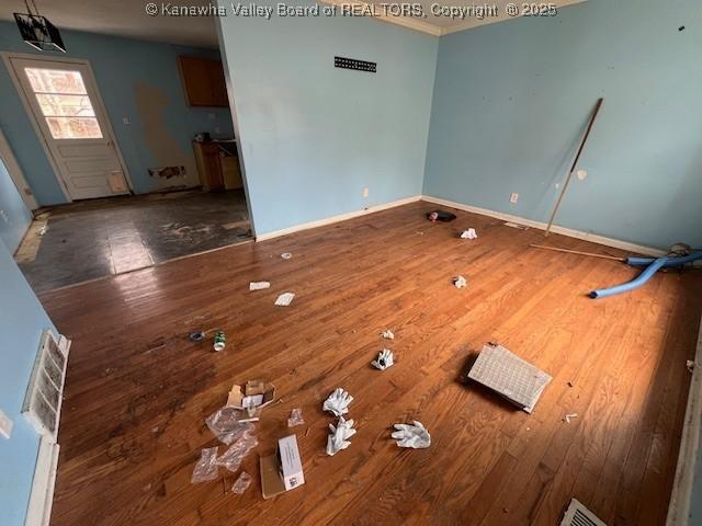 interior space featuring wood finished floors, baseboards, and ornamental molding