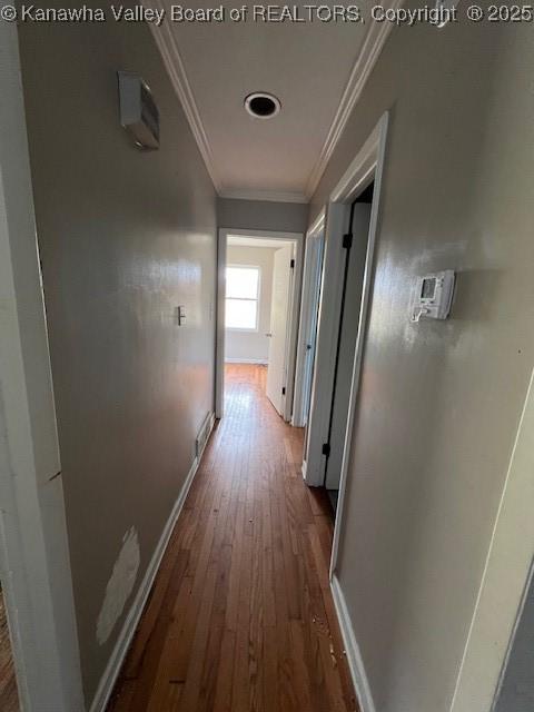 hallway with baseboards, dark wood-type flooring, and ornamental molding