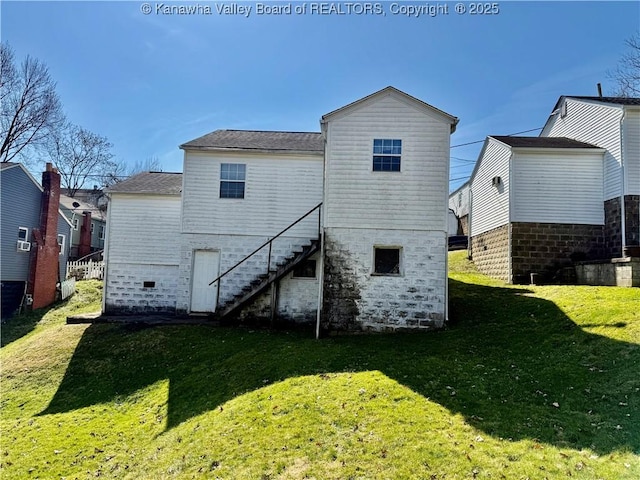 rear view of property featuring stone siding, stairs, and a yard