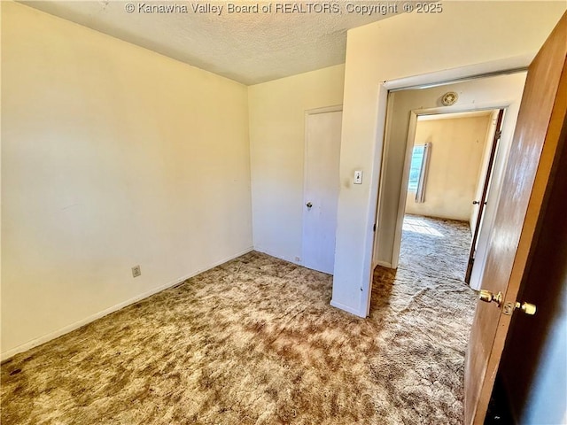 unfurnished bedroom with baseboards, carpet, and a textured ceiling