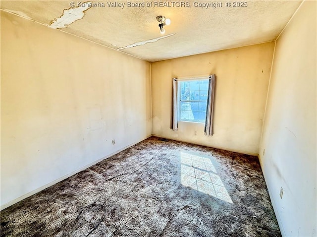 carpeted empty room with a textured ceiling