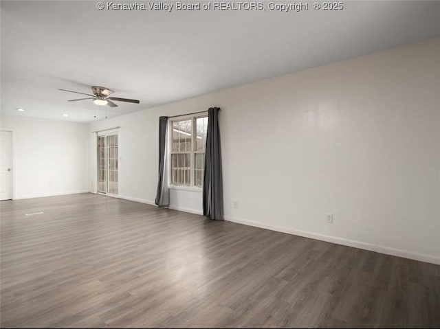 empty room featuring baseboards, ceiling fan, and wood finished floors