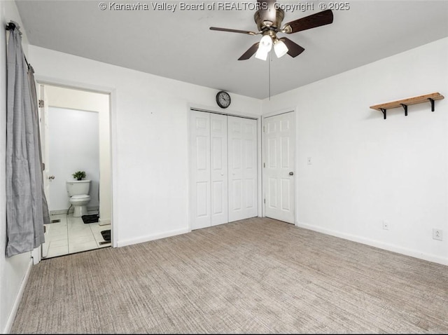 unfurnished bedroom with carpet flooring, connected bathroom, a ceiling fan, and baseboards