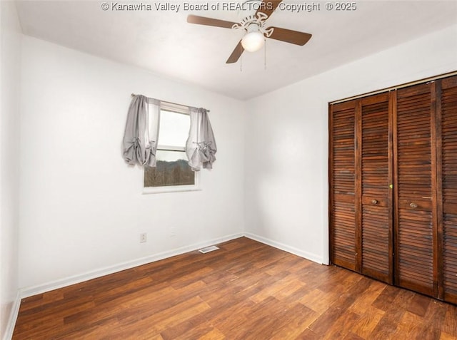 unfurnished bedroom with visible vents, a ceiling fan, wood finished floors, a closet, and baseboards