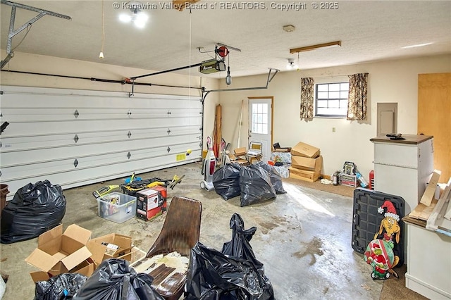 garage with electric panel and a garage door opener