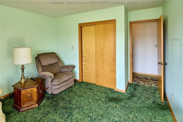 sitting room featuring baseboards, carpet floors, and a textured ceiling