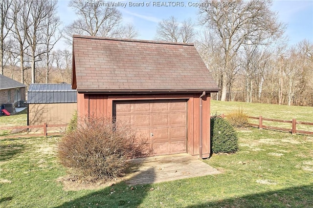 detached garage featuring fence