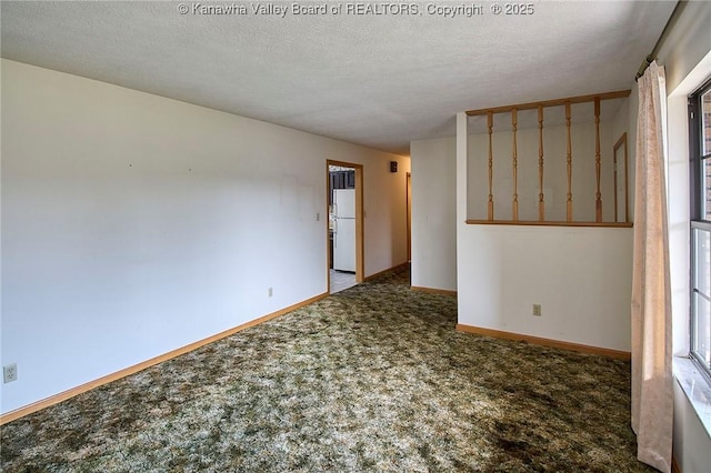 spare room featuring baseboards, carpet floors, and a textured ceiling