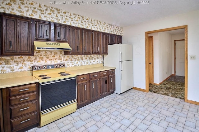 kitchen with white appliances, light countertops, baseboards, and under cabinet range hood