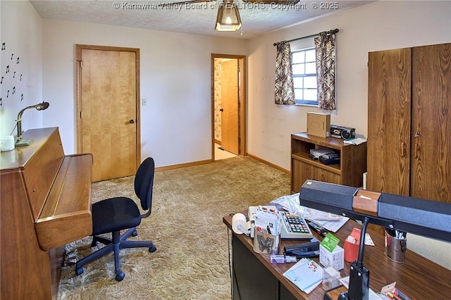 carpeted office with baseboards and a textured ceiling