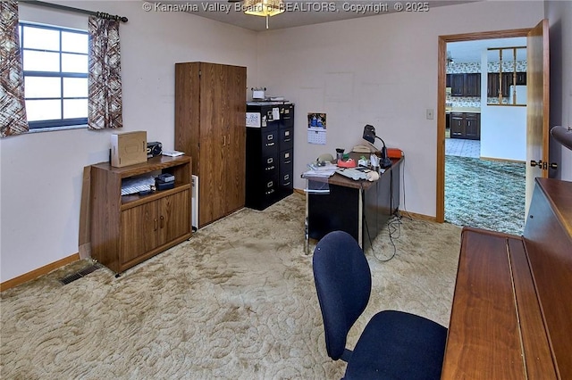 carpeted office space featuring visible vents and baseboards