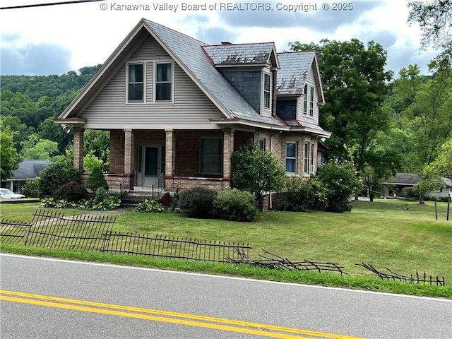 view of front of home with brick siding, a front lawn, and fence