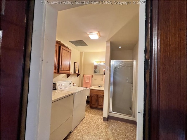 laundry room featuring cabinet space, washer and dryer, light floors, and a sink