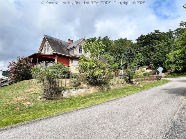 view of property exterior with a chimney and fence