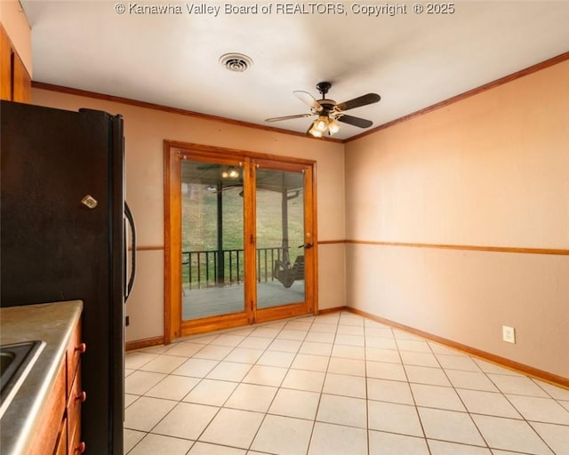 kitchen featuring baseboards, visible vents, freestanding refrigerator, ceiling fan, and ornamental molding