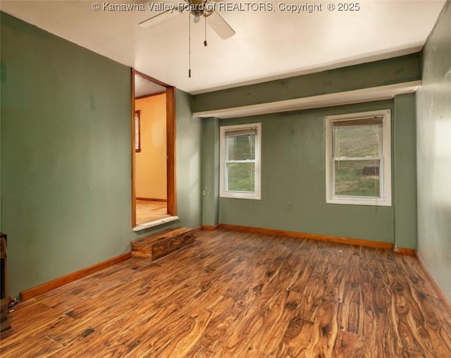 unfurnished room featuring baseboards, a ceiling fan, and wood finished floors