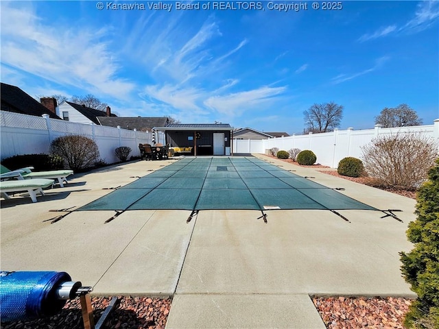 view of pool with a patio, a fenced backyard, a fenced in pool, and an outbuilding