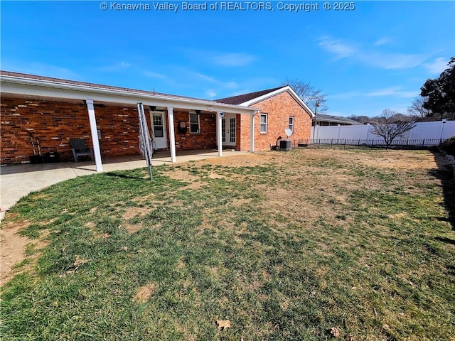 back of house with a yard, fence, brick siding, and french doors