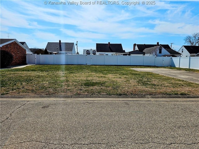 view of yard with driveway and fence