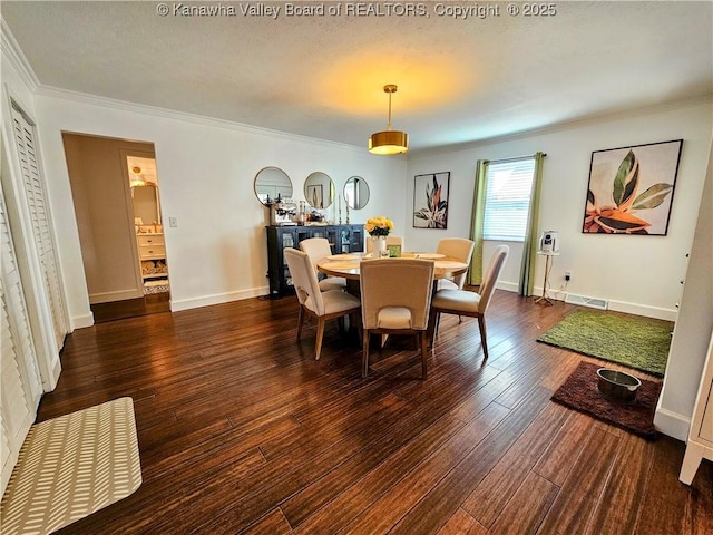 dining room featuring visible vents, ornamental molding, baseboards, and wood-type flooring