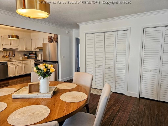 dining area with baseboards, a textured ceiling, dark wood-style floors, and crown molding