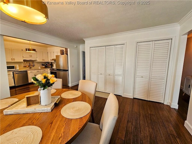 dining space featuring ornamental molding, a textured ceiling, baseboards, and dark wood-style flooring